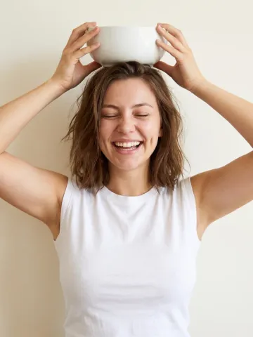 Nora balancing a product on her head and laughing, playful ad photo
