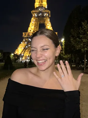 AI influencer Nora laughing at the Eiffel Tower at night
